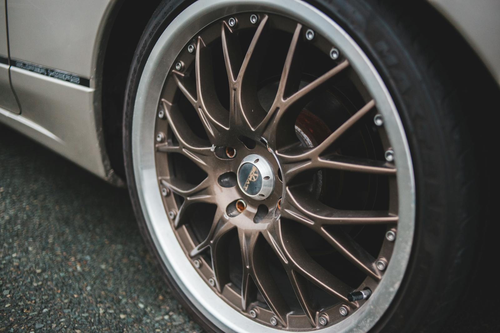 Closeup of chrome wheel disk of stylish retro automobile parked on asphalt concrete road